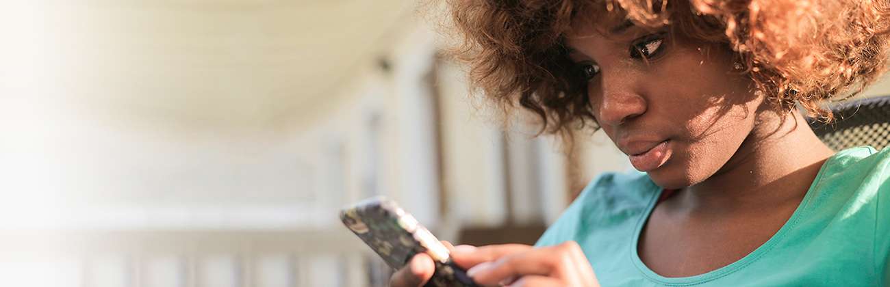 Young woman checks mobile device intently