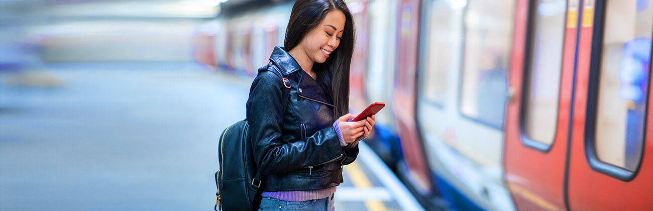 Asian woman in metro station using mobile device