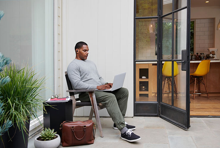 a guy sitting with a laptop on his lap